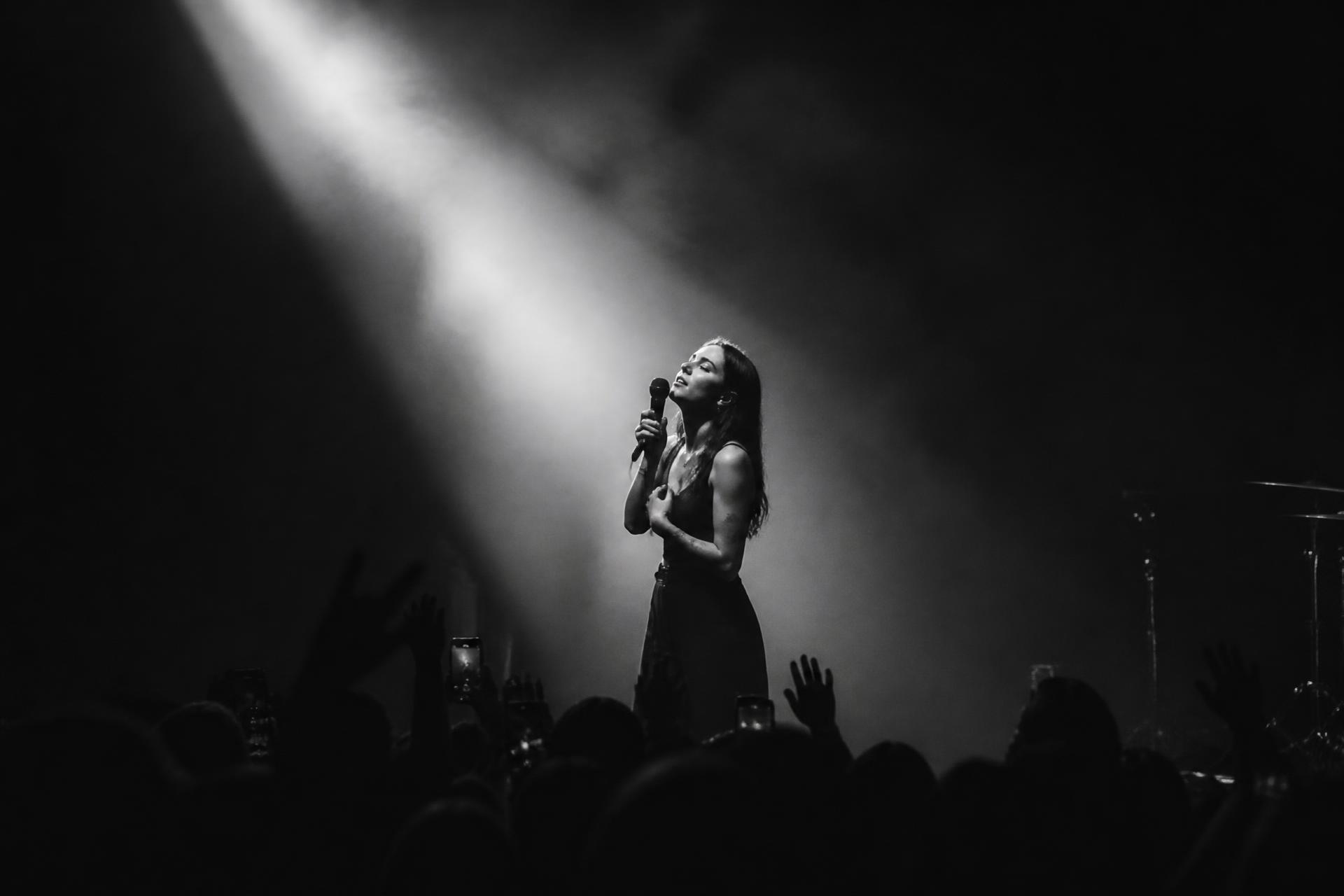 Performer on stage in a beam of light